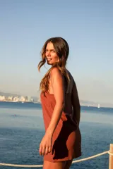 Vestido corto marrón de lino y rayón, con escote recto, tirantes finos y tajo lateral.