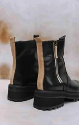 Botas de cuero marrón con suela track de goma negra, cierre lateral en color rojo y detalle de tira trasera al tono.