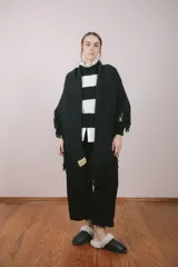 Ruana tejida a mano por artesanas uruguayas con lana 100% merino teñida artesanalmente, color negro con flecos.