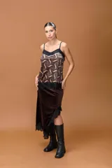 Top lencero de satén con estampado geométrico abstracto en tonos marrones y beige. Presenta escote en V con detalle de puntilla negra, breteles finos regulables y ruedo terminado con puntilla negra.