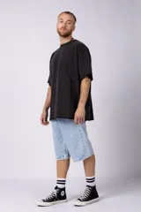 Remeron de algodón rústico con efecto de lavado gastado, corte oversize, cuello redondo y mangas cortas con terminaciones al corte.