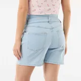 Bermuda de jean de tiro alto para maternidad, con faja elástica integrada de color celeste y diseño clásico de cinco bolsillos.