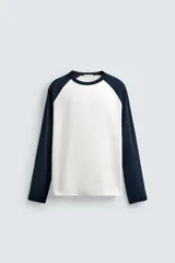 Camiseta de corte relajado con cuello redondo y mangas largas tipo raglán en contraste.