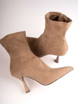 Botín de gamuza color beige, con punta fina y taco de aguja.