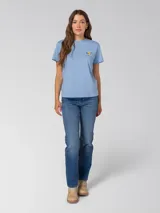Remera de algodón color azul claro, con cuello redondo y mangas cortas. Presenta un pequeño estampado gráfico en el pecho izquierdo.