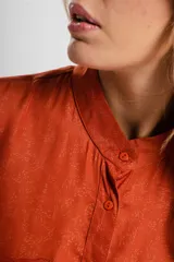 Camisa verde con cuello mao, de manga larga con puños abotonados y cierre frontal con botones.