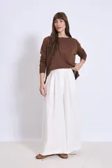 Jersey de punto de manga larga en color marrón, con cuello redondo y diseño holgado.