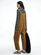 Mono largo de pana color verde oscuro, con breteles finos y silueta relajada de pierna amplia.