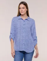 Camisa azul con estampa geométrica, de corte clásico y calce relajado, con cuello camisero tradicional, cierre frontal de botones y mangas largas con presillas para arremangar.