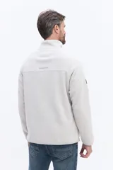 Buzo de polar color marrón con cuello alto y cierre frontal parcial. Presenta un bolsillo frontal con cierre en contraste de color y mangas largas.