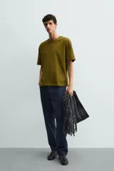 Remera de corte relaxed fit confeccionada en tejido de algodón con textura irregular, cuello redondo y manga corta.