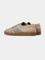Zapatillas urbanas de diseño retro en tonos beige, marrón y celeste, confeccionadas en serraje con suela de goma color caramelo y cordones blancos.
