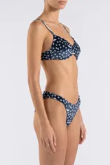 Top de bikini de terciopelo azul marino con estampado de lunares y detalles gráficos, tirantes finos ajustables y soporte estructurado.