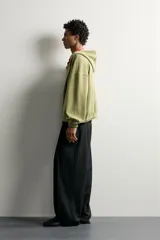 Cazadora relaxed fit de hombre, confeccionada en tejido estructurado tipo waffle con efecto lavado en color verde. Cuenta con cuello con capucha, cierre frontal con cremallera, bolsillos frontales tipo canguro y acabados elásticos en puños y bajo.