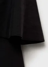 Vestido corto negro con diseño de volado en el pecho, tirantes finos y corte entallado.