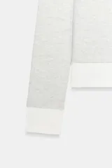 Camiseta de manga larga color gris melange, con cuello redondo y bajo recto. Presenta un detalle de tejido efecto doble a contraste en el cuello, puños y dobladillo inferior en color blanco.