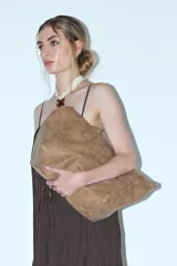 Cartera tipo shopper de cuero vegano en color marrón con acabado efecto gastado. Presenta un diseño amplio y flexible, ideal para uso diario.