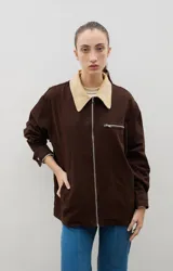 Campera de jean azul oscuro con cuello de pana en color crema. Presenta cierre frontal metálico, bolsillo con cierre en el pecho y bolsillos laterales. Diseño de corte holgado con mangas largas.