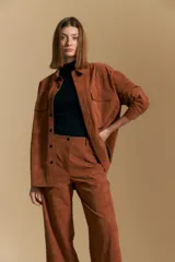 Pantalón de corte ancho y silueta relajada, confeccionado en tejido de efecto gamuzado color marrón oscuro. Presenta un diseño de tiro alto con cierre frontal y bolsillos laterales.