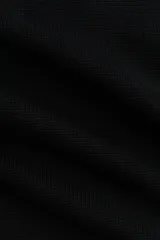 Top en punto suave, de color negro, corte ceñido al cuerpo, cuello alto y mangas cortas con aberturas en los hombros.