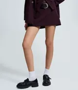 Short pollera de estilo sastre con diseño estructurado, cintura con trabillas y cinturón desmontable con hebilla metálica.