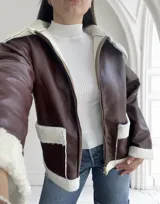 Campera marrón de ecocuero con interior de corderito blanco, cierre frontal con cremallera y bolsillos laterales.