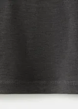 Camiseta gris de manga larga y cuello redondo, con diseño ajustado al cuerpo.