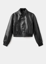 Chaqueta corta de cuero ovino color negro, con cuello camisero, cierre frontal con botones, mangas largas con puños elásticos y bolsillos laterales.