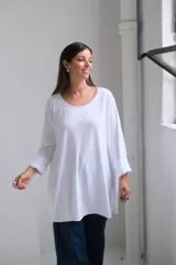 Remera blanca de corte oversize y diseño holgado, con cuello redondo y mangas largas con puños doblados.