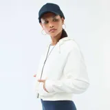 Buzo crop top con capucha, color blanco, con cierre frontal completo, mangas largas y puños acanalados.