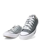 Championes urbanos Converse modelo Chuck Taylor All Star Ox, de corte bajo, confeccionados en lona color gris con puntera y suela de goma blanca.