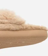 Pantuflas abiertas de peluche color beige, con elástico en el talón y suela marrón.