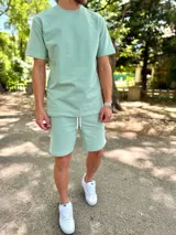 Conjunto deportivo para hombre compuesto por una remera de manga corta con cuello redondo y un short con cordón ajustable en la cintura, ambos en color verde menta.