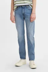 Jean de corte skinny con tiro medio, confeccionado en denim azul con efecto de lavado desgastado.