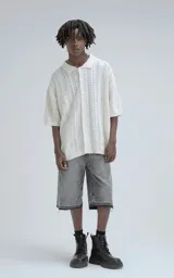 Camisa de punto abierto (crochet) color beige, manga corta y cuello polo, con calce oversize.