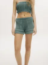 Short tejido de crochet color verde, con detalles en ochos y puntos calados, y pretina con elástico.