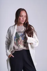 Cárdigan negro tejido con diseño de ochos, corte holgado y bolsillos frontales.