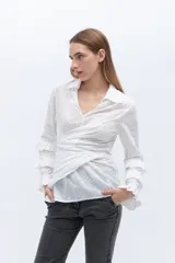 Camisa blanca de algodón con diseño cruzado y mangas largas con volados.