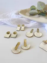 Aros colgantes con base plateada y dije circular de guampa color crema.