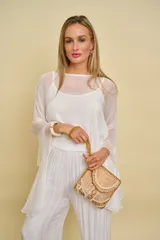 Blusa blanca liviana y translúcida, de corte amplio y mangas largas acampanadas, con escote redondo.