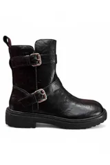 Bota baja de color negro con suela chunky texturizada, puntera redonda y caña media. Cuenta con dos tiras con hebillas metálicas plateadas decorativas en la parte superior e inferior del lateral exterior, y presilla trasera.