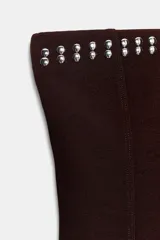 Top tipo bandeau negro de tejido elástico, con escote recto, hombros descubiertos y detalle de tachas metálicas en el borde superior.