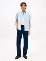 Camisa celeste de corte regular, confeccionada en algodón Oxford con cuello abotonado, manga corta y logo de Tommy Hilfiger bordado en el pecho.