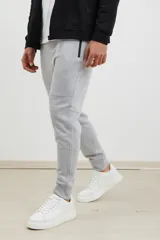 Pantalón jogging de corte slim, con puños elastizados, cintura con cordón ajustable, cierres laterales engomados y bolsillo tipo parche lateral.