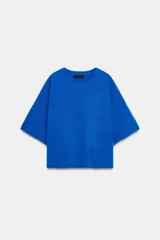 Jersey de punto liso color azul eléctrico, con cuello redondo y mangas anchas de corte caído.