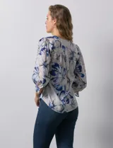 Blusa de gasa estampada con flores azules y blancas, marca Sioni. Tiene escote en V, abertura frontal con botones y mangas 3/4 con puños fruncidos y botón.
