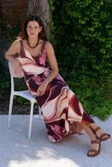 Vestido largo sin mangas de corte evasé con estampado abstracto en tonos bordó, beige y rosado, escote en V y tirantes finos.