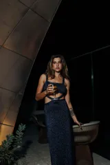 Vestido largo marrón de tejido de punto con lurex, escote cuadrado, breteles finos y aberturas laterales en la cintura y falda.