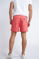 Short de baño con cintura elástica y cordón ajustable, confeccionado en tela ligera de secado rápido. Presenta un estampado botánico integral en tonos amarillos, blancos y azules, con dos bolsillos delanteros y uno posterior.