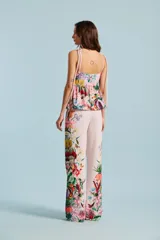 Pantalón Natalia Antolín de corte recto y tiro alto, color rosado claro con estampado floral colorido en la parte inferior de las piernas.